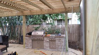 Outdoor kitchen with custom wood deck with shade arbor